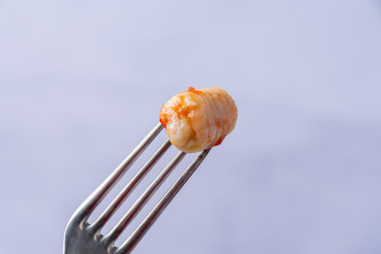 Fork with a gnocchi with tomato sauce.