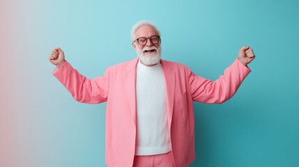 Fototapeta premium An elderly man radiates happiness as he raises his arms in celebration, dressed in a striking pink suit with a white sweater, set against a blue and pink gradient background.