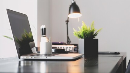 Laptop on a minimalist desk with motivational quotes and a plant