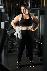 Fototapeta premium A confident young woman in activewear exercises, promoting body positivity at the gym.