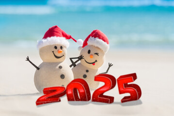 A funny greeting card featuring a cheerful sandy snowmen on a beautiful white sand beach.  3D numbers for the New Year stand in the sand.