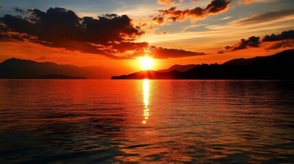 Obraz premium Sunset over Water with Mountain Silhouette