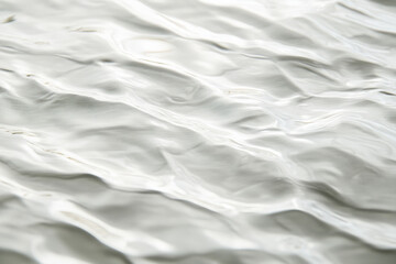 Obraz premium A light white textured surface with a subtle, rippled effect, mimicking the gentle undulations of a serene water surface.