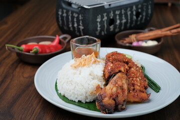 Traditional barbecue chicken Asian with hot chili sauce and rise served on white plate as top view and side view
