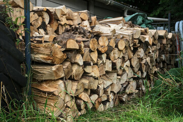 Stack of firewood, with logs neatly arranged between stakes.