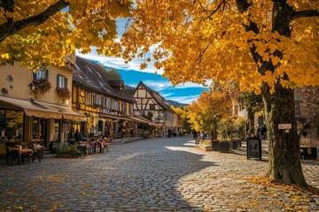 Obraz premium Charming autumn street scene with vibrant yellow leaves. Cobblestone path lined with lively cafes. Warm sunshine casts a golden hue. Generative AI