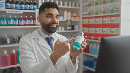 Hispanic pharmacist with beard examines medicine in a drugstore