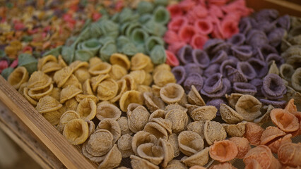 Colorful orecchiette pasta displayed outdoors in bari, italy, showcasing vibrant hues, traditional craftsmanship, and puglian culinary culture.