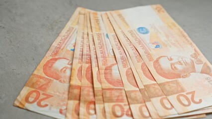 Philippine banknotes spread out on a concrete surface, showcasing currency details vividly.