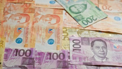 Philippine banknotes scattered, displaying various denominations and colorful designs, representing the republic of the philippines' currency in focus.