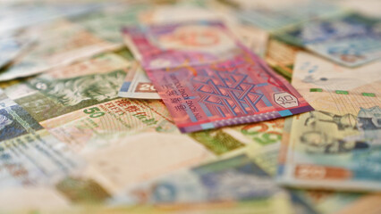 Hong kong banknotes scattered closely on a table showcasing the vibrant variety of currency in...