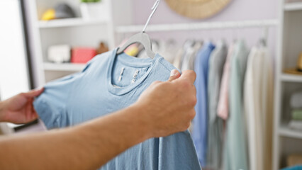 A person browsing through a selection of shirts in a well-organized, modern wardrobe.