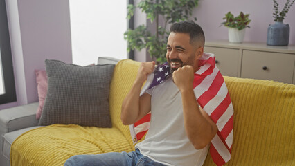 Hispanic man smiling holding american flag in a modern living room