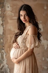 Naklejka premium Pregnant woman in beige gown smiling softly