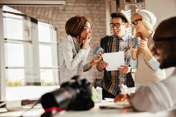 Designer team collaborating on project with blueprints in office