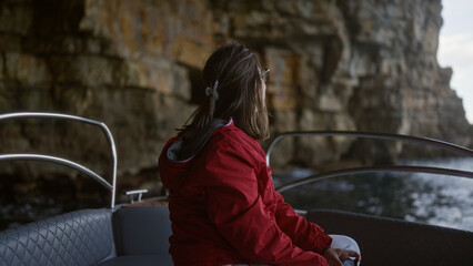 Young hispanic woman on a boat exploring a stunning cove in polignano a mare, puglia, italy, with...