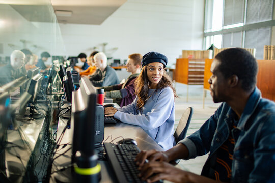Diverse students working on computers in library