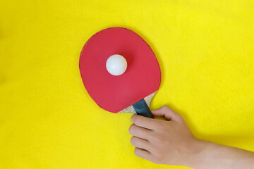 Table tennis racket with the ball for playing ping pong on yellow background. Sports concept.