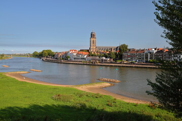 Obraz premium View towards the historic city center of Deventer, Overijssel, Netherlands, with Lebuinus church and the river IJssel in the foreground