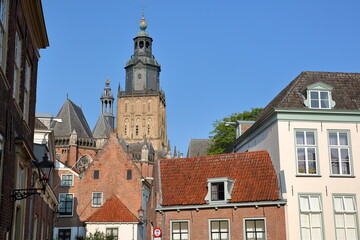 Fototapeta premium Traditional historic medieval houses in the old picturesque town of Zutphen, Gelderland, Netherlands, with the bell tower of Saint Walburgiskerk church in the background