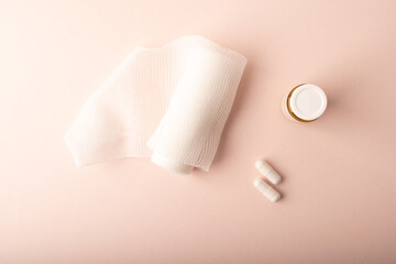 Pills, medical jar and bandage top wiev on pink. Medicine and womens health concept banner. Medicinal treatment deseases. Copy space. High quality photo