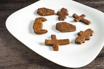 A white plate with home made cookies in the shape of Halloween figures. Halloween cookies.