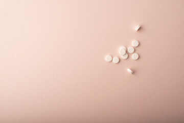 White pills close up isolated on pink background. Medicine dose. Concept of medicinal treatment, vitamins, antibiotic, supplements, contraceptive pills. Womens health banner. High quality photo