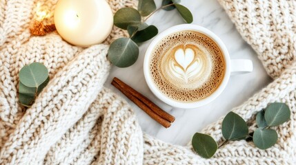 Relax with this serene flat lay showcasing a beautifully crafted coffee, accompanied by cinnamon sticks and eucalyptus leaves, all on a marble table