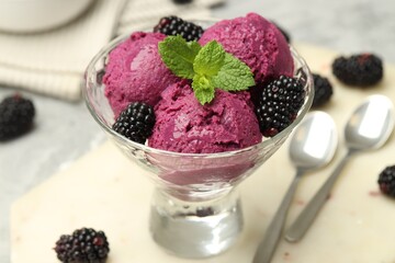 Delicious blackberry sorbet, fresh berries and mint in glass dessert bowl on table, closeup