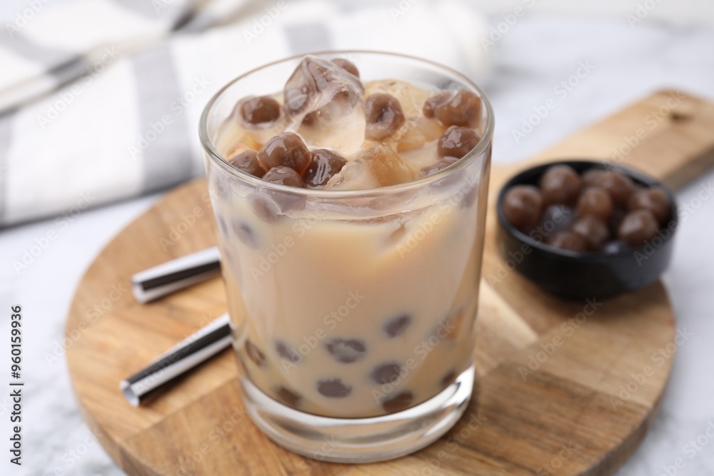 Sticker Tasty milk bubble tea in glass, tapioca pearls and straws on white marble table, closeup