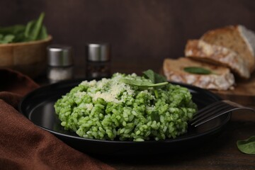 Delicious spinach risotto with parmesan cheese served on table, closeup
