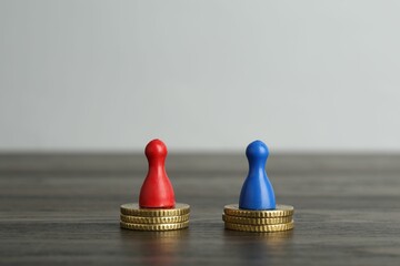 Financial equality. Human figures and coins on wooden table