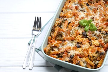 Delicious al forno pasta in baking dish on white wooden table, closeup