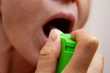 person using mouth spray to cure the throat