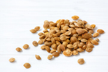 A pile of apricot pits on a light background. View from above. Vitamin B 17. Healthy food.