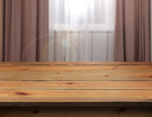 Empty wooden table near window with curtains. Space for design