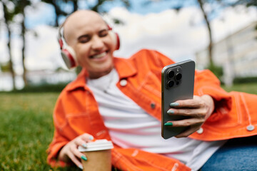 A vibrant young woman relaxes in a lush green park, immersed in her favorite tunes.