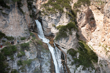 aerial view of the waterfalls produced in the val di fanes veneto with people on the via ferrata