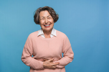 Emotional happy elderly mature woman female pensioner with curly brown grey hair laughing out loud...