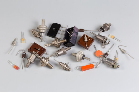 Different old semiconductor diodes in various packages on gray surface