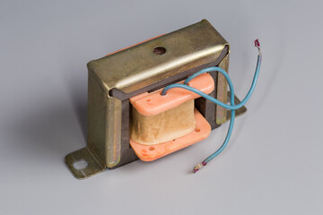 Old small-sized mains transformer on a gray surface