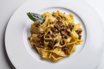 Plate with pappardelle with wild boar ragout sauce with bay leaf
