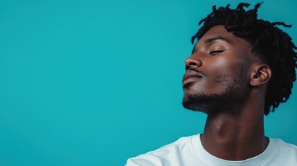 Obraz premium A person wearing a white outfit is photographed against a vivid teal background, showcasing a mix of modern fashion and a tranquil, thoughtful vibe.