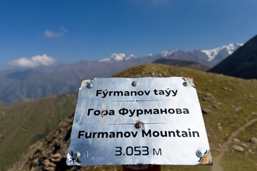 Information sign Furmanov Peak on the top of the mountain