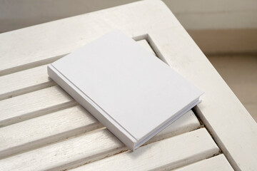 blank book cover mockup on wooden outdoor table, hotel balcony or terrace
