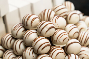 sweets covered with white chocolate and brown lines close-up