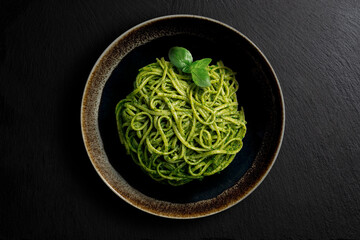 Dark bowl with linguine with Genoese pesto sauce