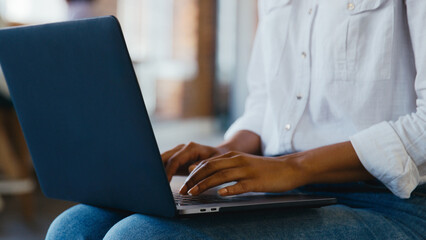 Close Up Of Businesswoman Working Typing On Laptop Resting On Her Knees In Office 