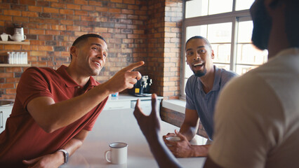 Multi-Cultural Businessmen Taking Coffee Break In Kitchen Area Of Modern Open Plan Office Together