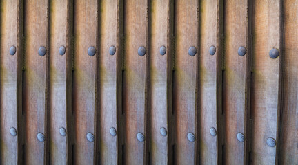 vertical boards wall with bolts nails close up background